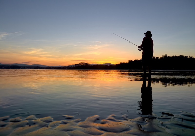 Picture of a man fishing with a beautiful sunset