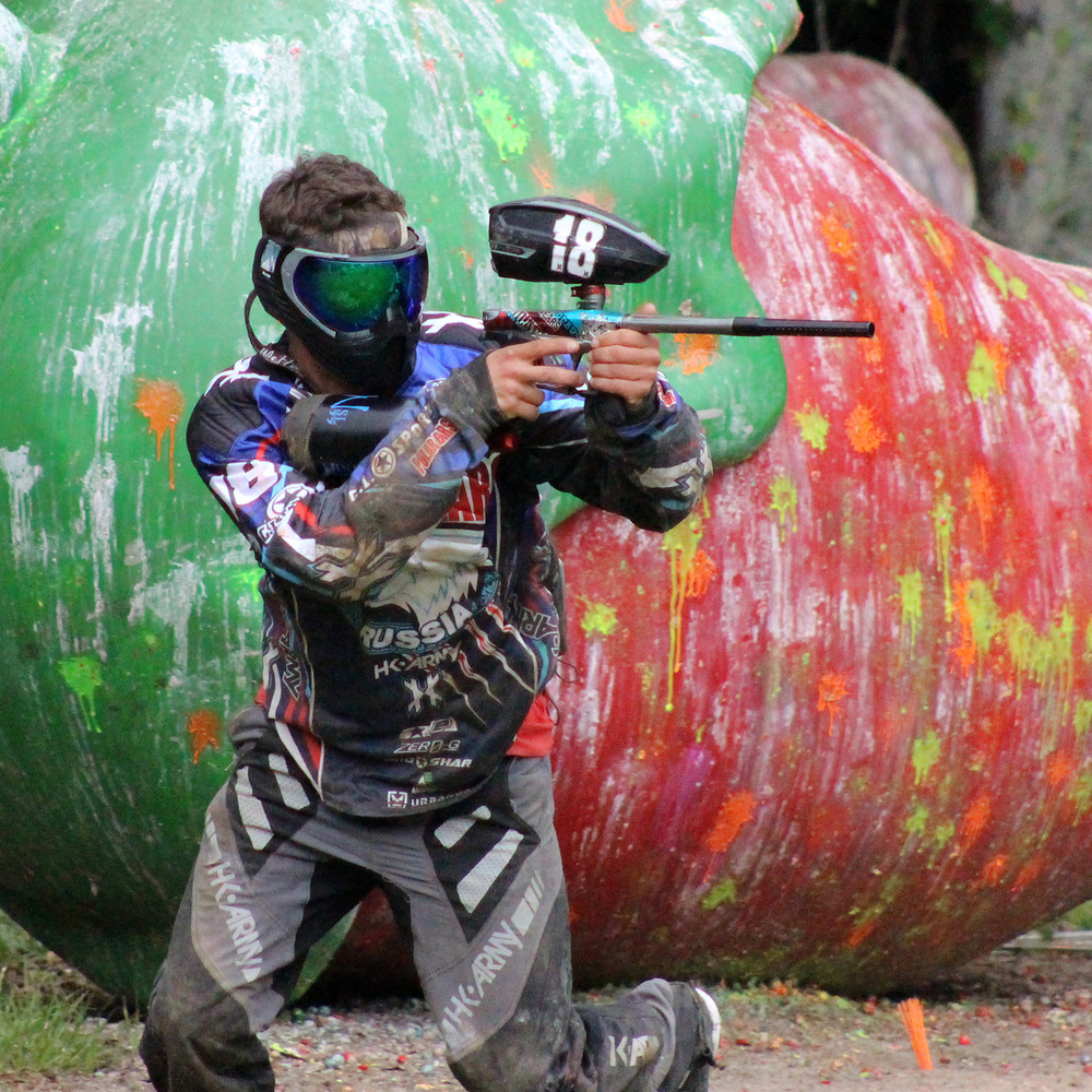 Picutre of man running and shooting paintballs